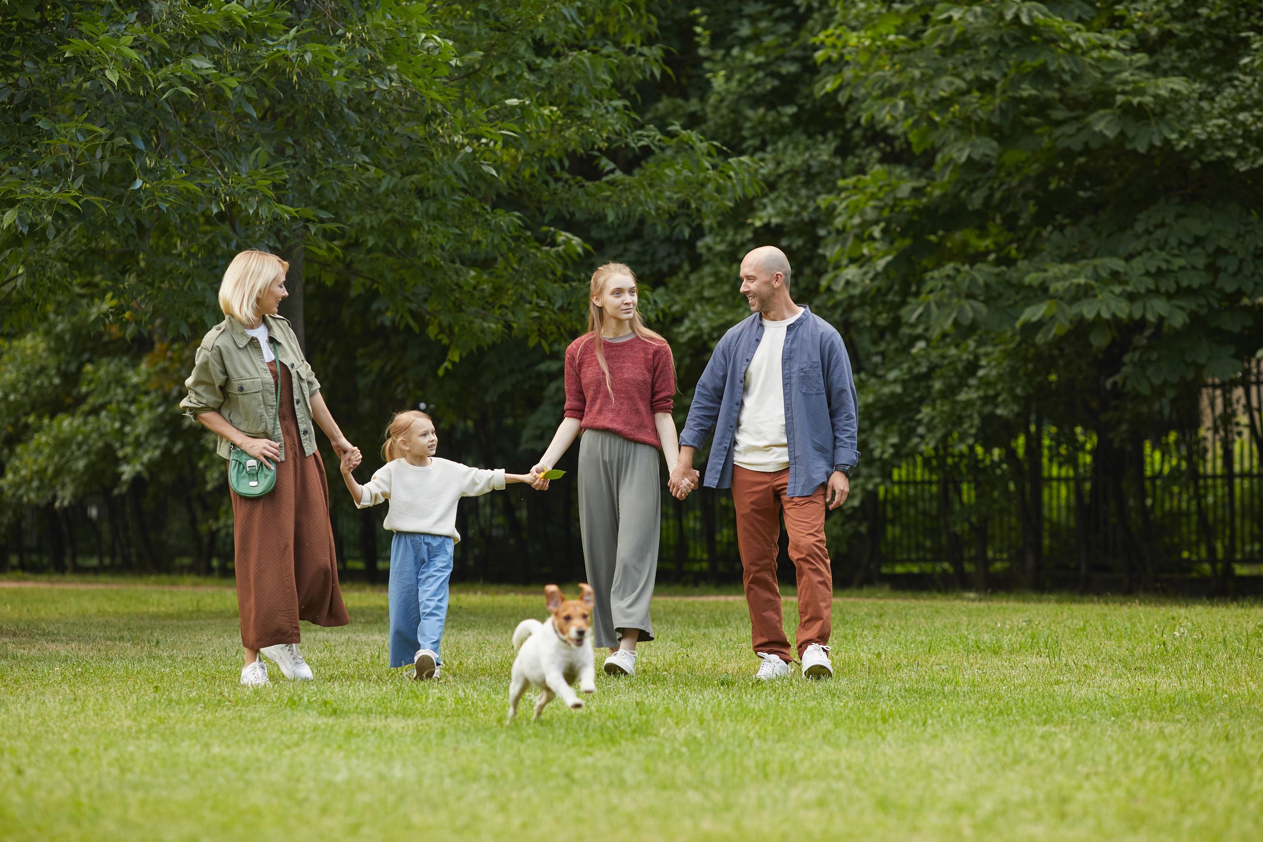 family with dog walking in park